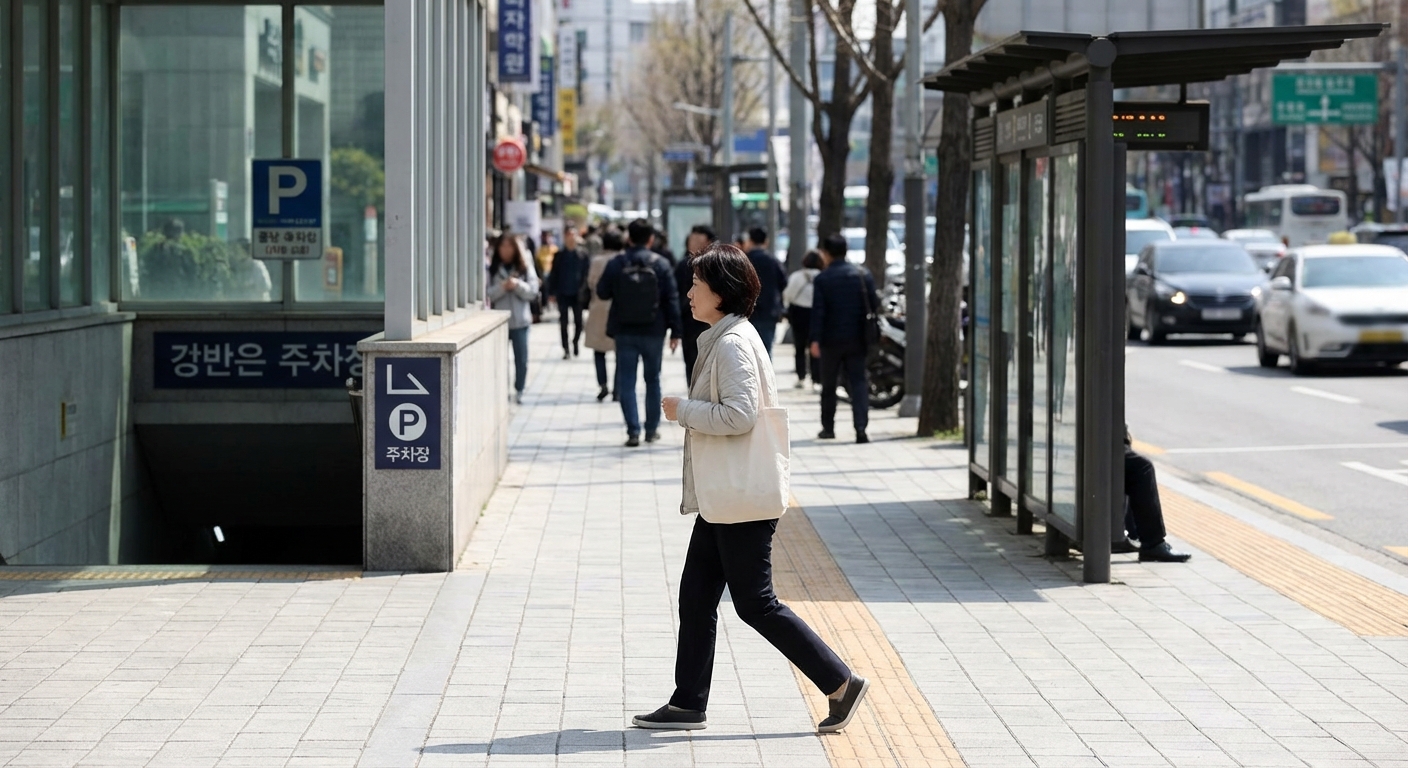 한 한국인 성인이 공영 주차장에서 버스 정류장으로 향해 걸어가는 모습.